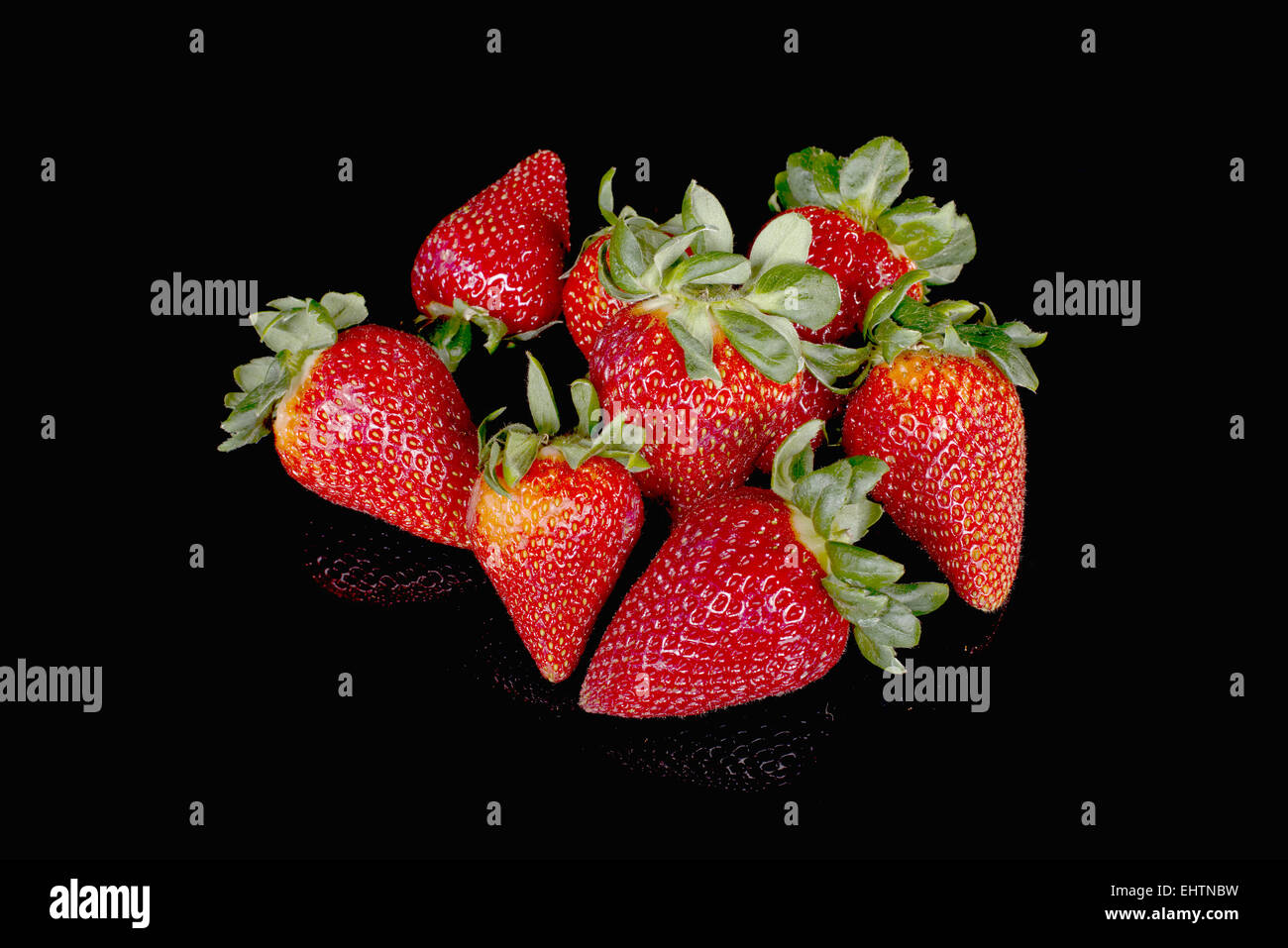 pile of strawberries on black background Stock Photo - Alamy