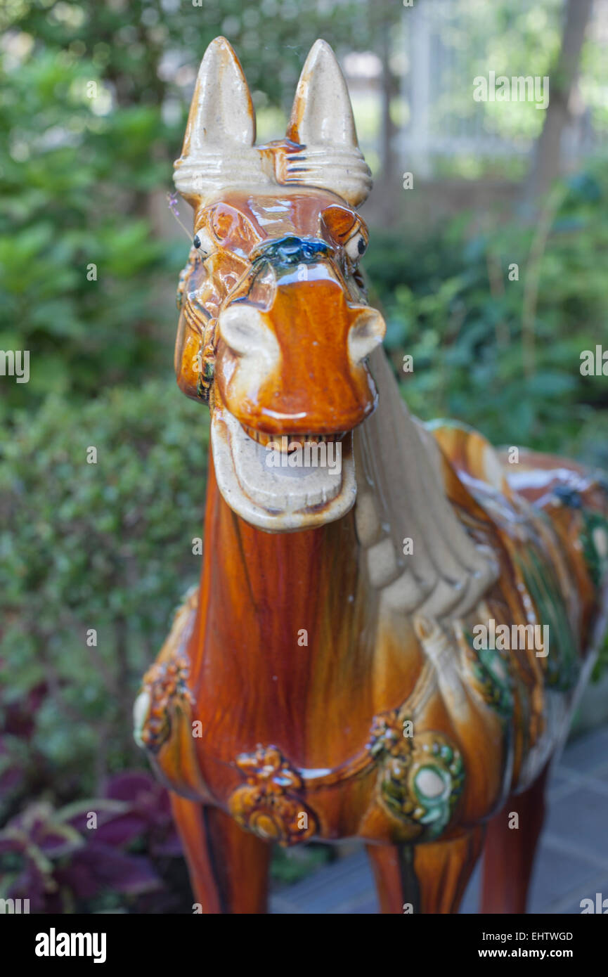 A Sancai style horse figurine makes a garden ornament in Japan. Stock Photo