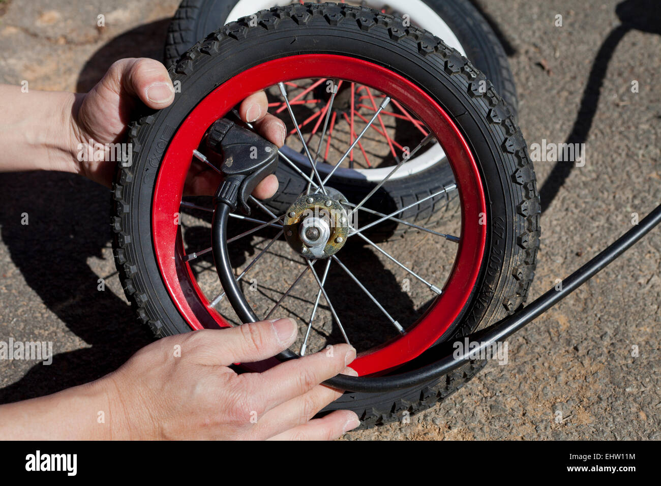 Man pumping air into child's bicycle wheel - USA Stock Photo