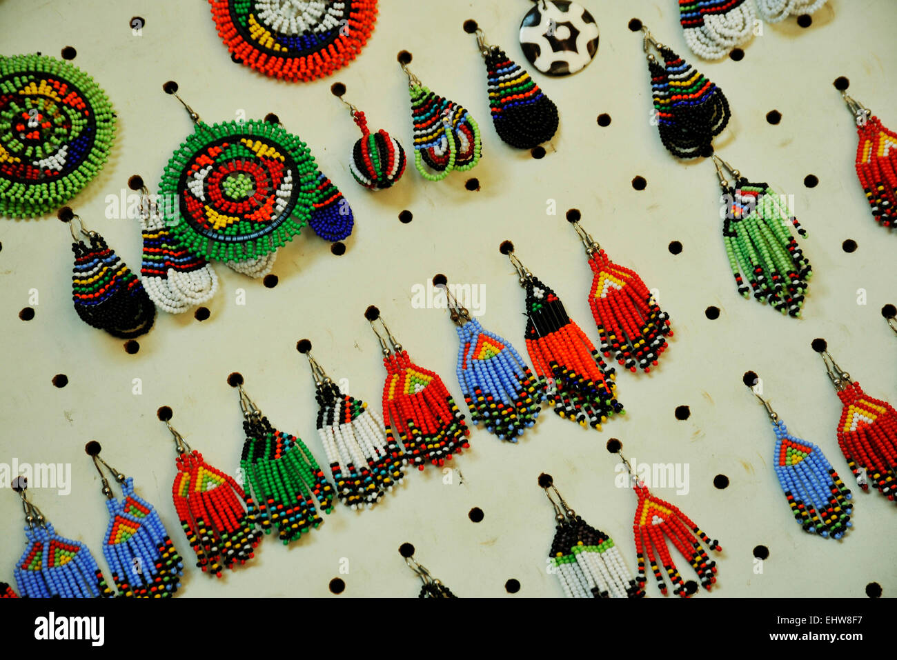 Curio shop display with rows of multi-coloured earrings in traditional Zulu beadwork style, tourist souvenirs for sale in South Africa Stock Photo