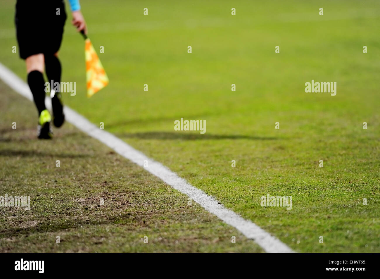 Assistant referees running along the sideline during a soccer match Stock Photo