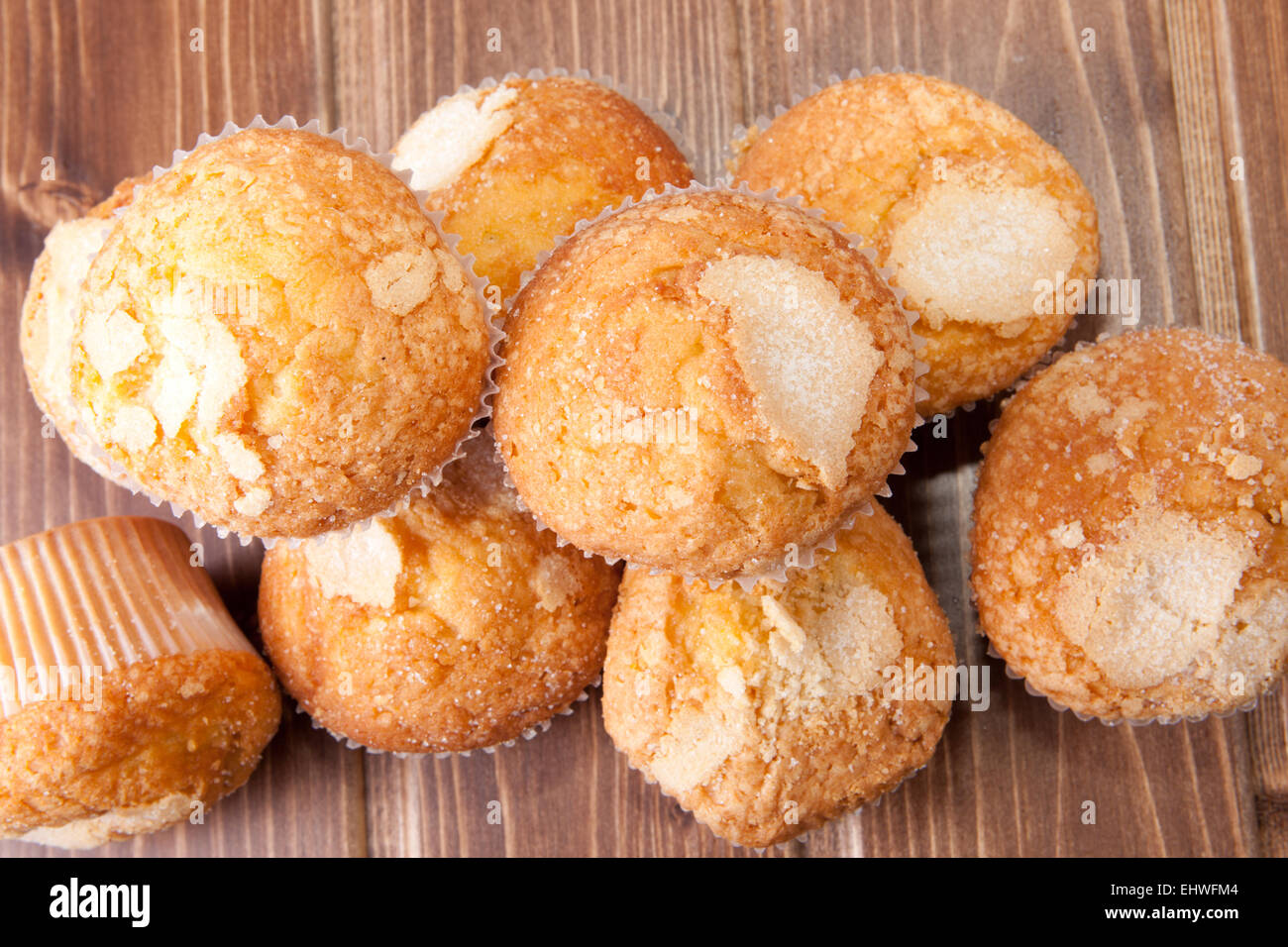 Traditional madeleines made with olive oil. Spanish typical small cake. Isolated over wooden surface Stock Photo