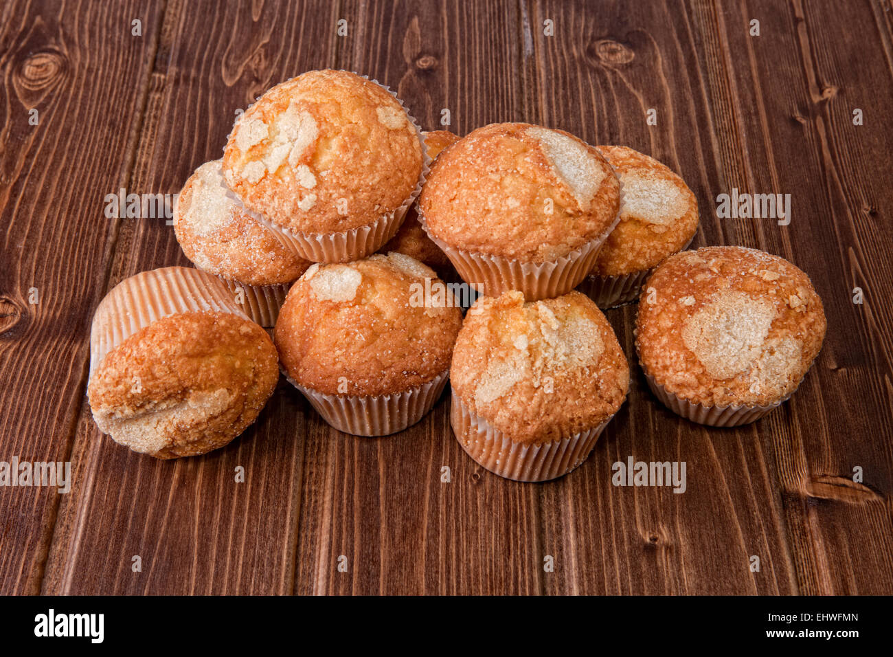 Traditional madeleines made with olive oil. Spanish typical small cake. Isolated over wooden surface Stock Photo