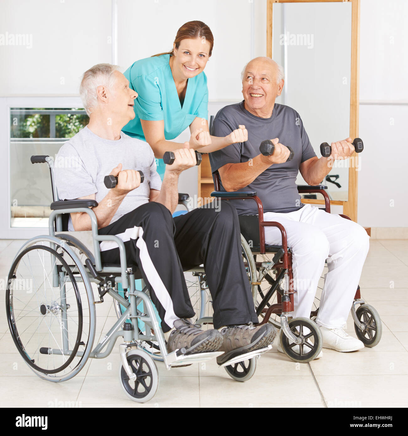 Physiotherapist with two senior men in wheelchairs lifting dumbbells Stock Photo Alamy