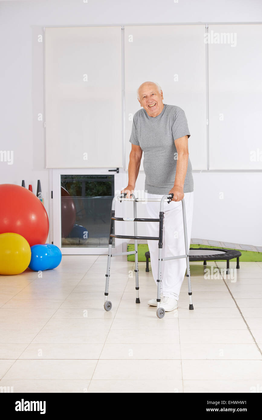 Smiling old senior man with walker in physiotherapy Stock Photo