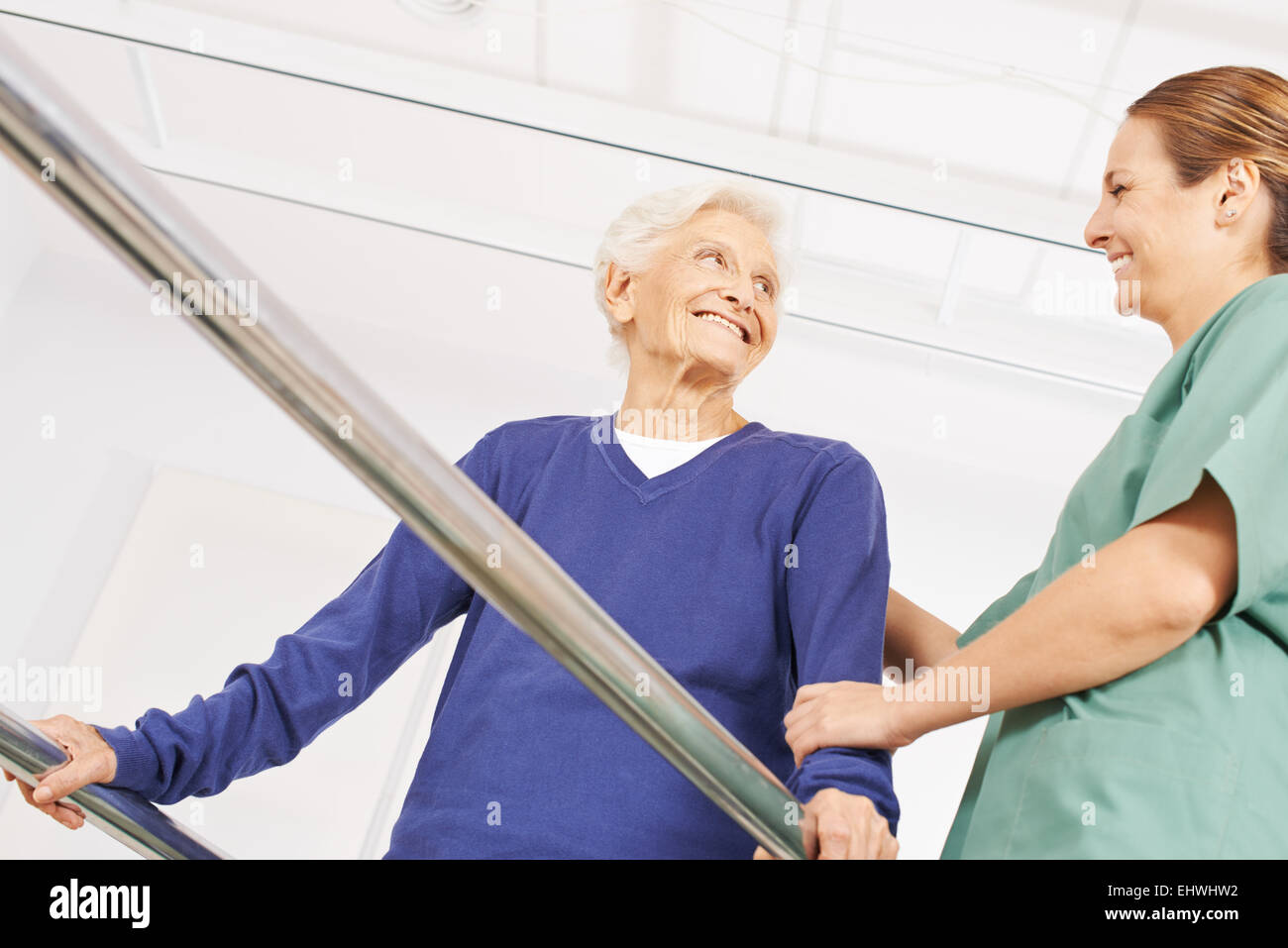 Smiling old woman in physiotherapy on a treadmill with physiotherapist Stock Photo