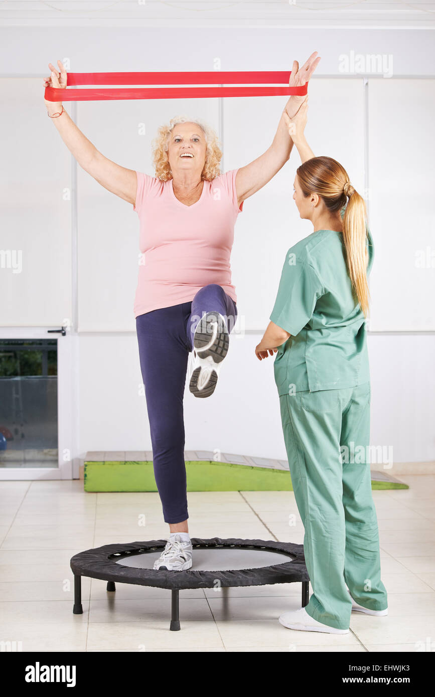 Old woman exercising with latex band in physiotherapy Stock Photo