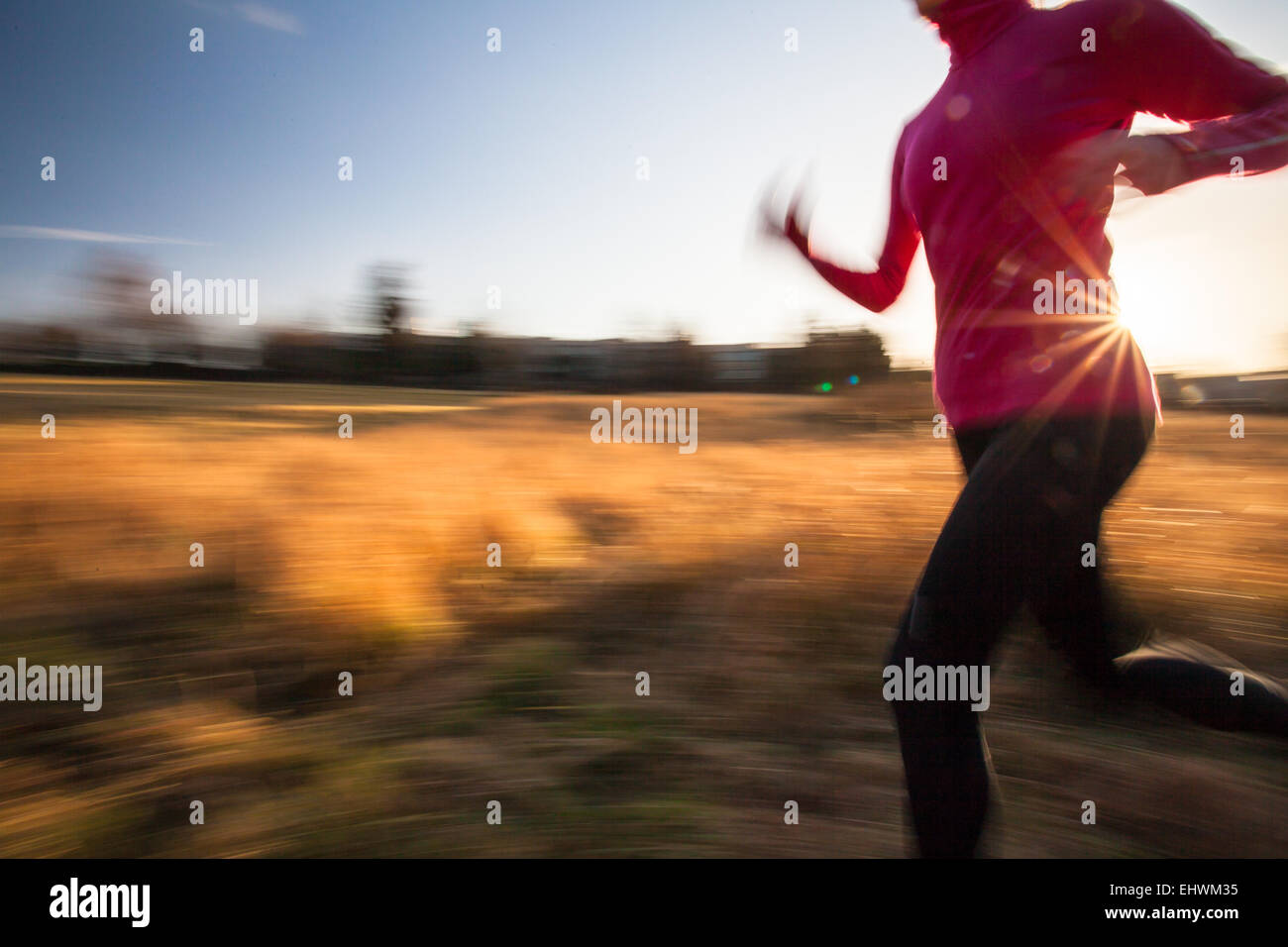 Young woman running outdoors on a lovely sunny winter/fall day (motion ...