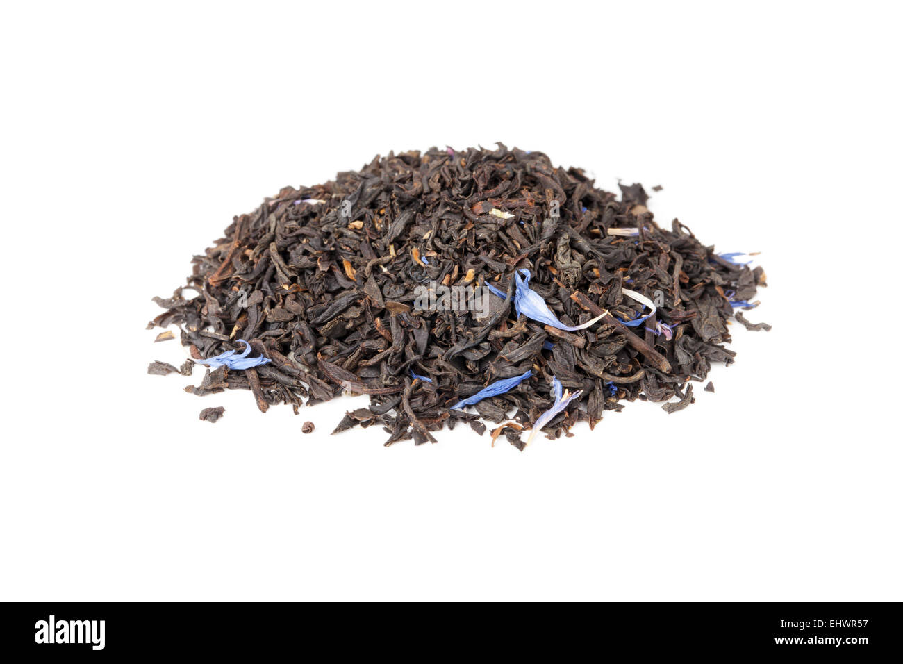 Small pile of big leaf black tea mixed with blue cornflower petals and pieces of bergamot isolated on white background Stock Photo