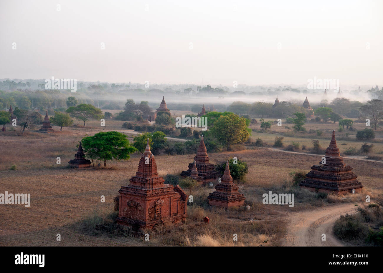 A misty dawn breaks amongst the many temples of Bagan Myanmar Stock Photo