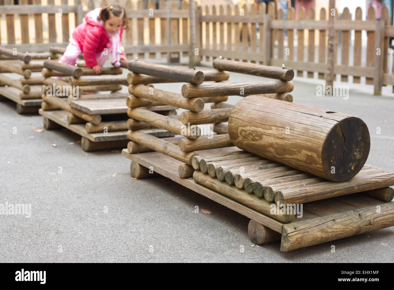 Toddler playing over a wooden train, children playground in public park Stock Photo