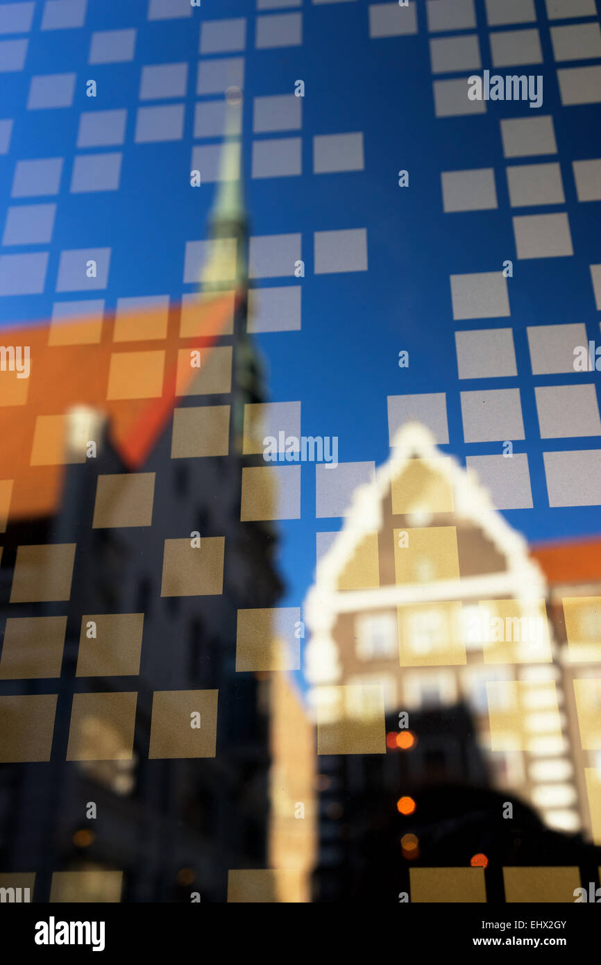 Reflection city with cathedral spire in the window of the house with glued squares Stock Photo