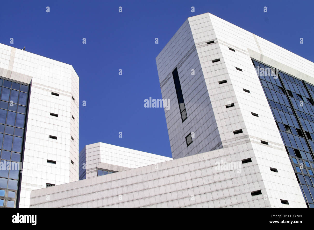 Modern sleek office building with white marble tiles in a blue sky Stock Photo