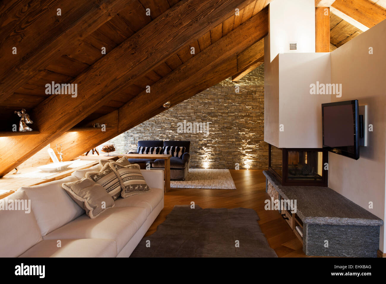 Luxury living room in Alpine cottage with fireplace and stony wall Stock Photo