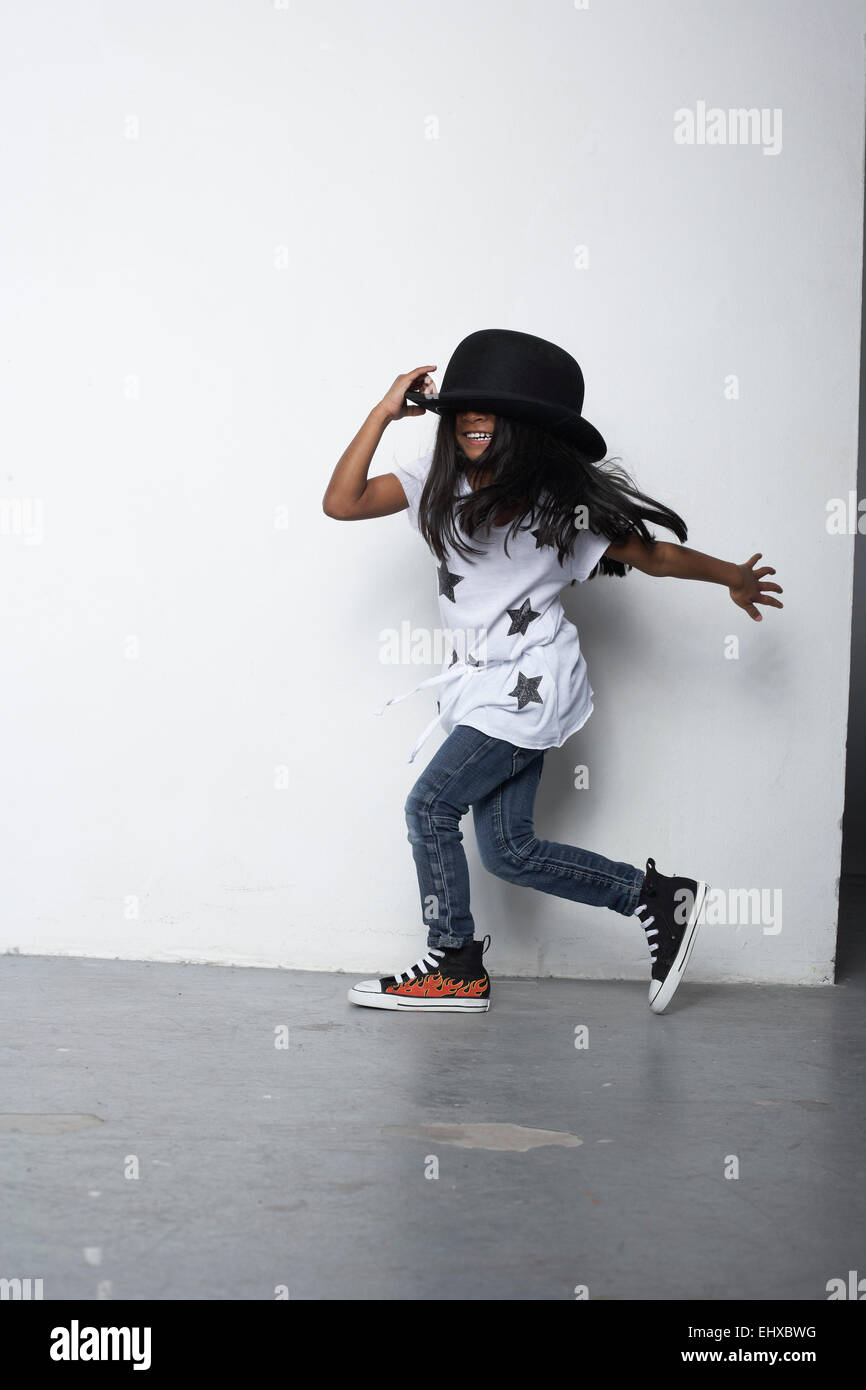Running girl wearing bowler hat Stock Photo - Alamy