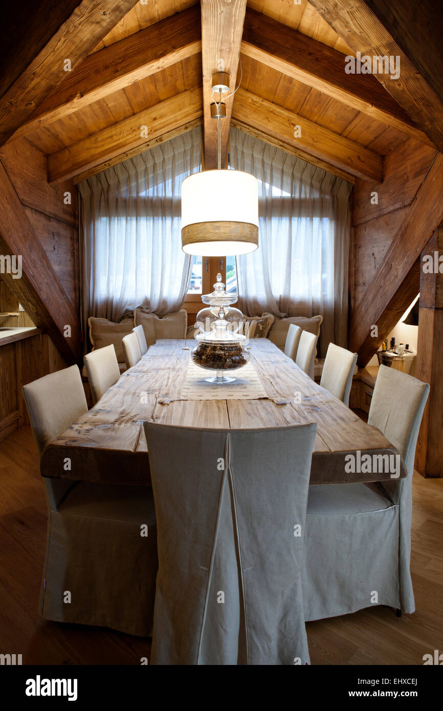 Alpine attic dining room table for eight people Stock Photo