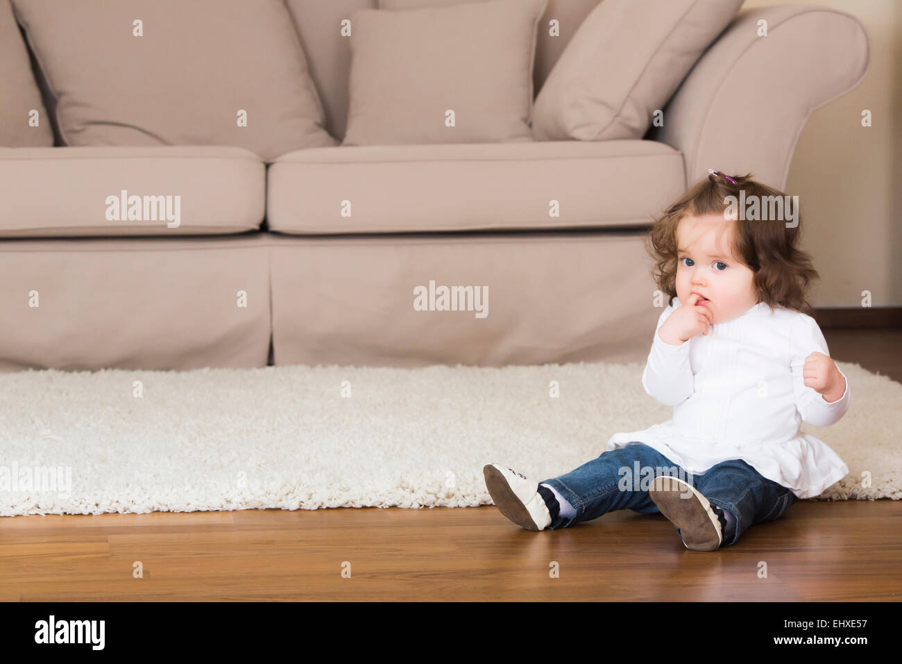 Little girl sitting on the floor Stock Photo - Alamy