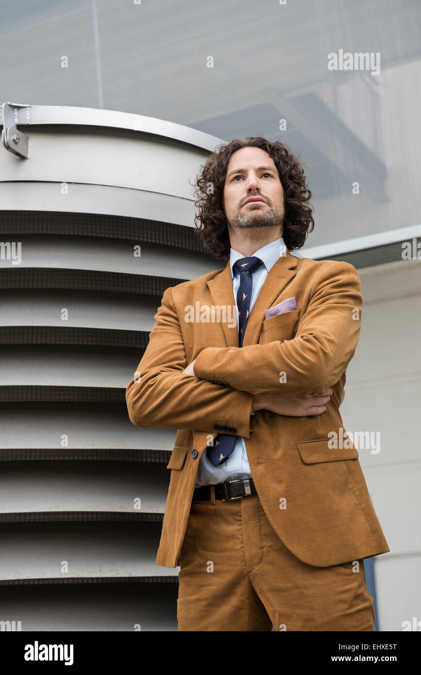 Businessman standing in front of ventilation shaft Stock Photo