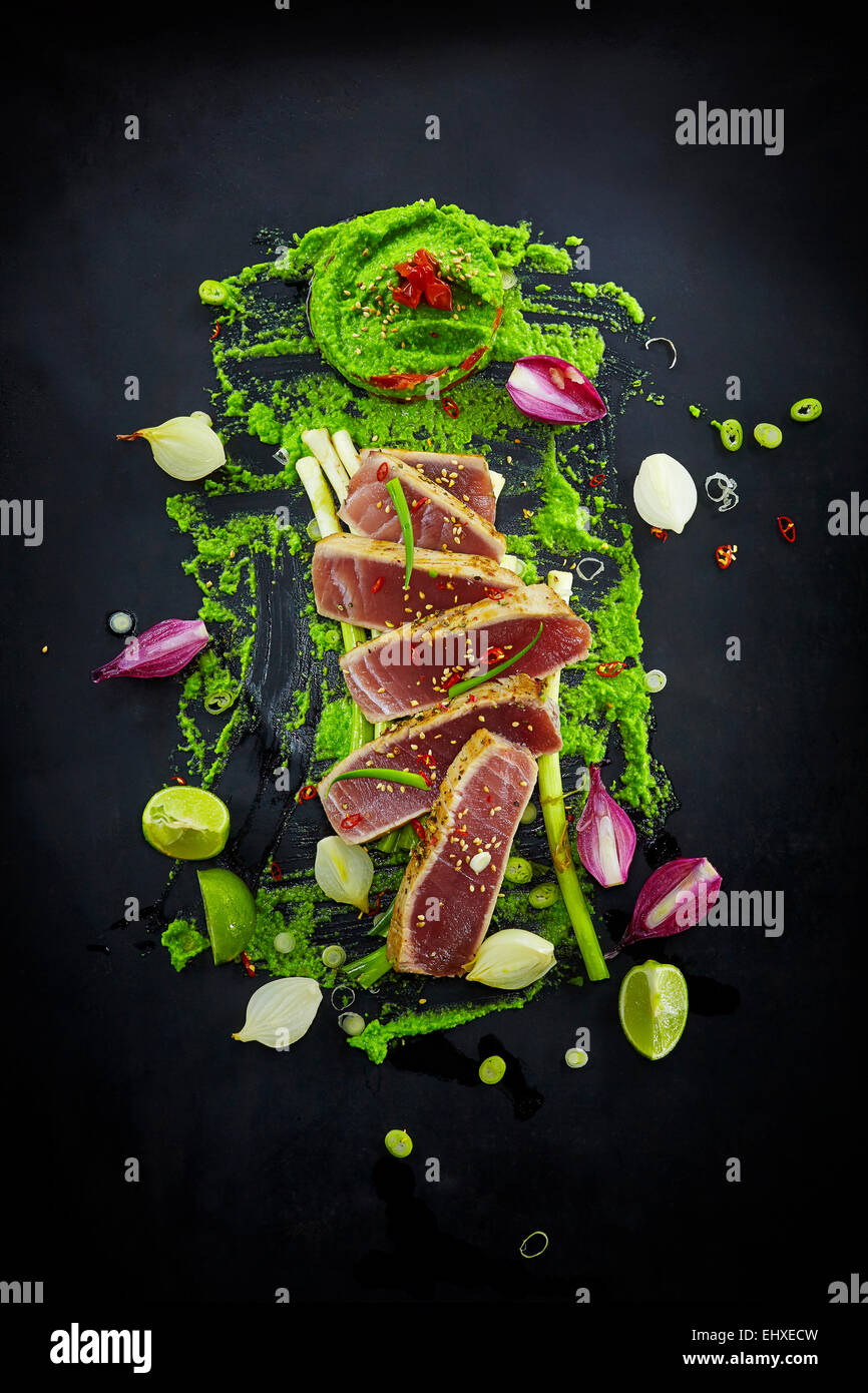 Foodart, slices of raw tuna with herbs and wasabi pea paste Stock Photo