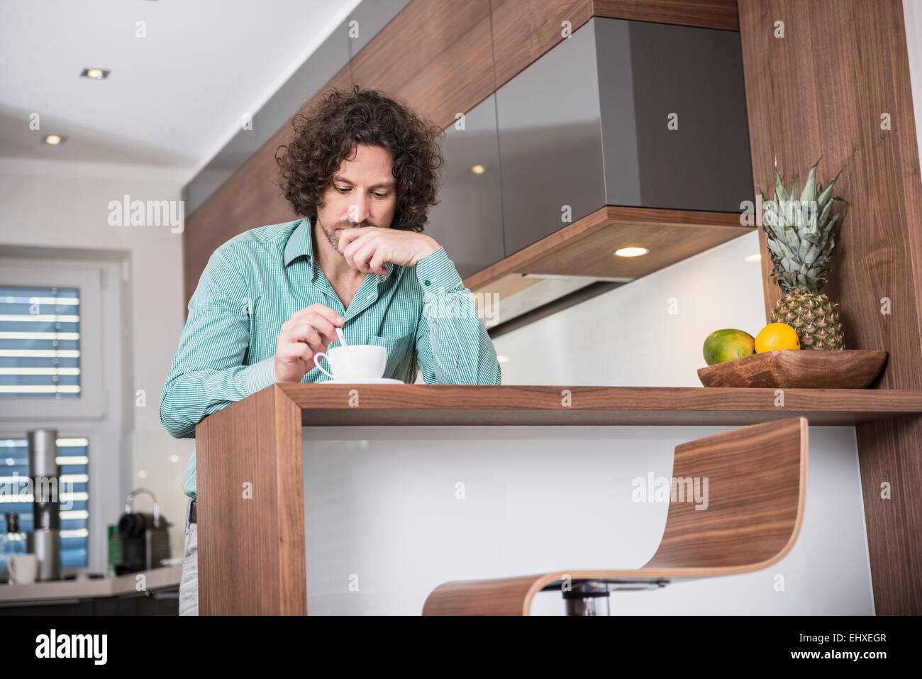 Man drinking cup of coffee in a kitchen, Munich, Bavaria, Germany Stock Photo