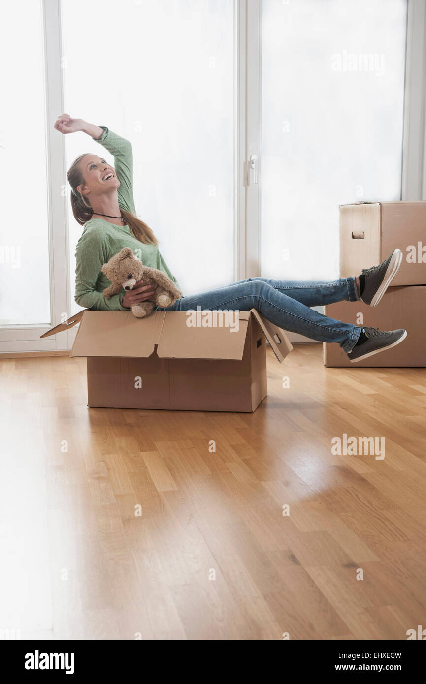 Cheerful Young woman sitting in a cardboard box, Bavaria, Germany Stock ...