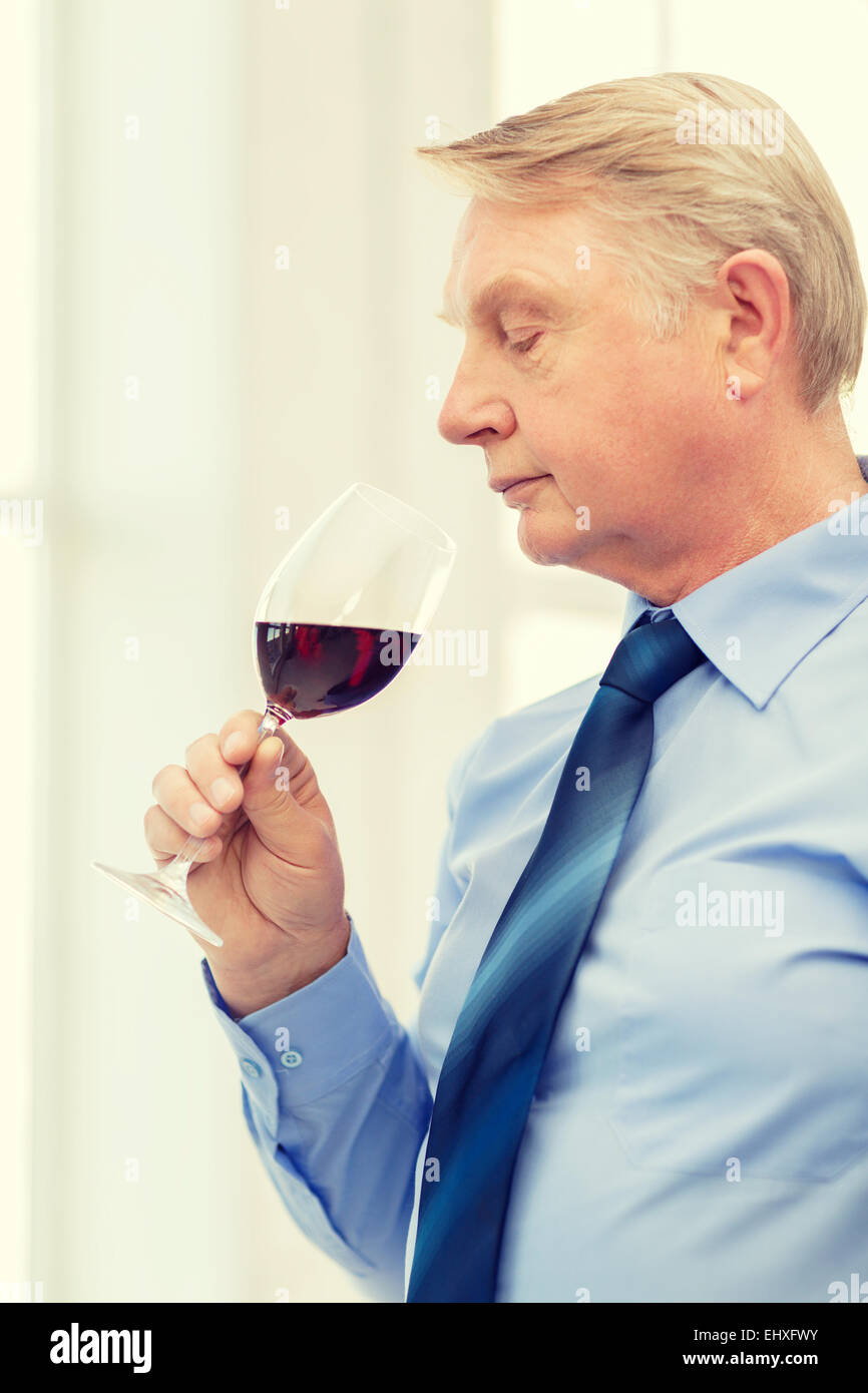 older man smelling red wine Stock Photo - Alamy