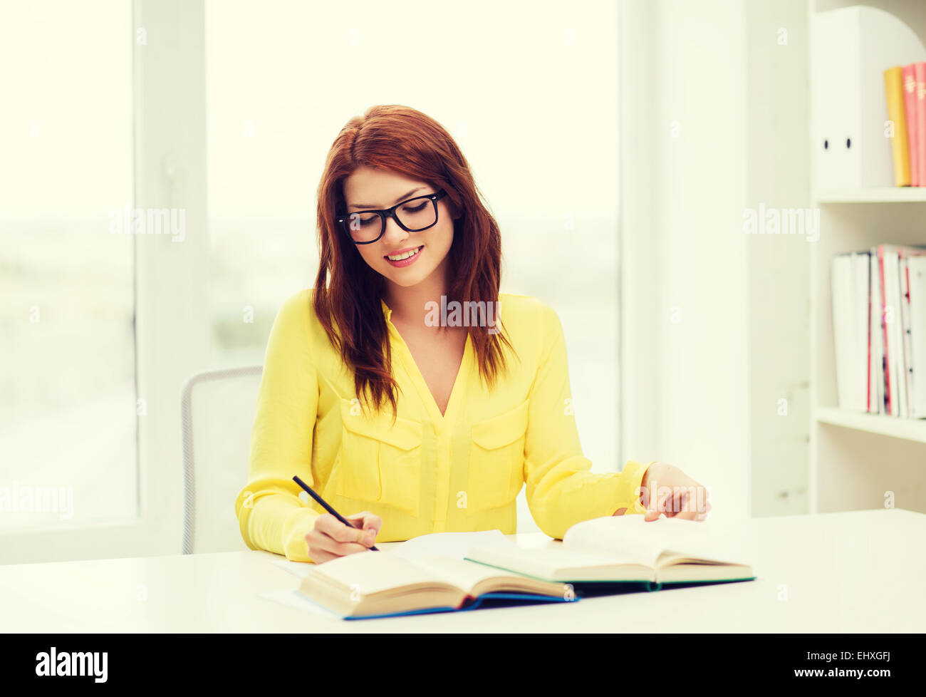 smiling student girl reading books in library Stock Photo - Alamy
