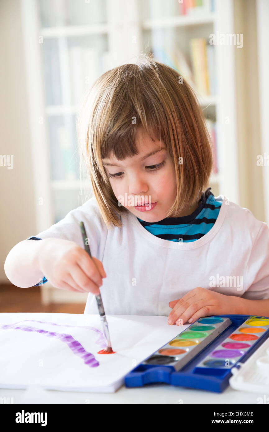 Portrait of smiling little girl painting with watercolours Stock Photo ...