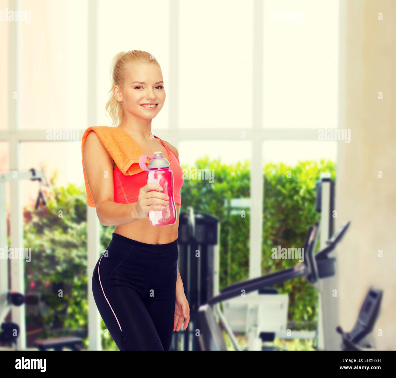 smiling sporty woman with water bottle and towel Stock Photo - Alamy