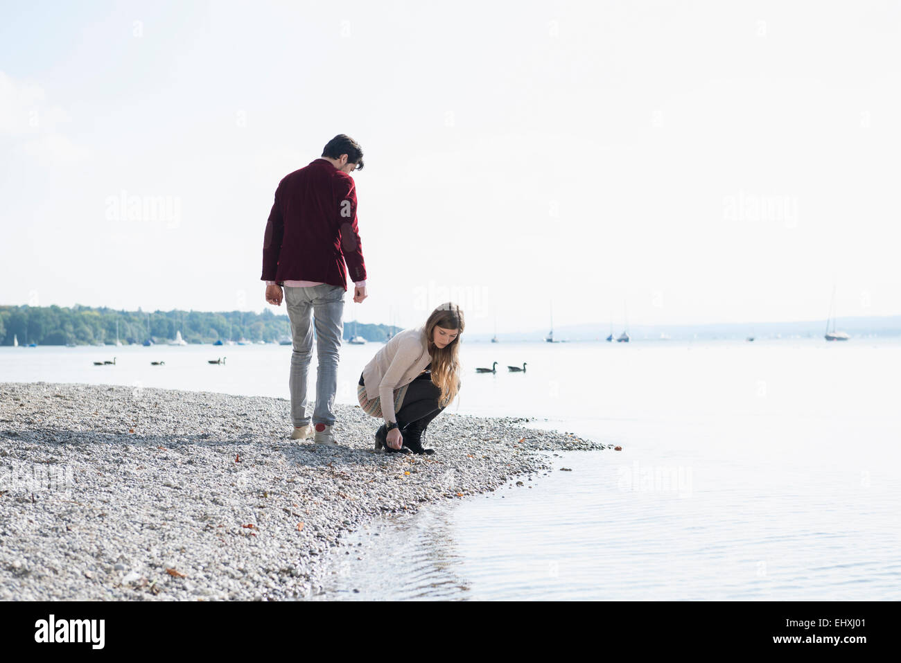 Young couple lake shore gathering pebbles Stock Photo