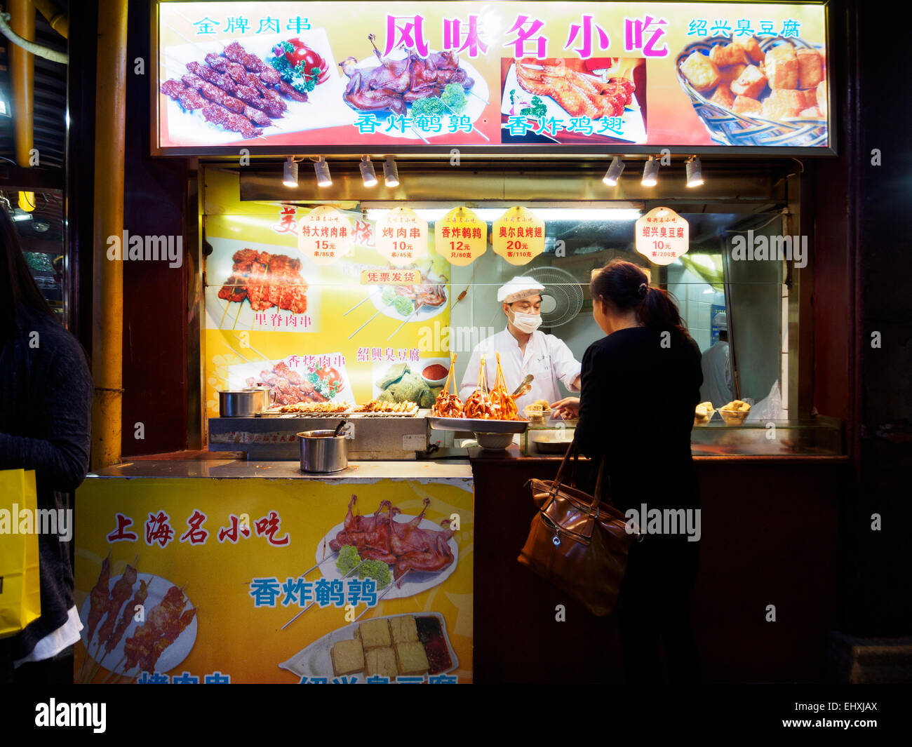 Woman buying food from street vendor in Shanghai, China, Asia Stock