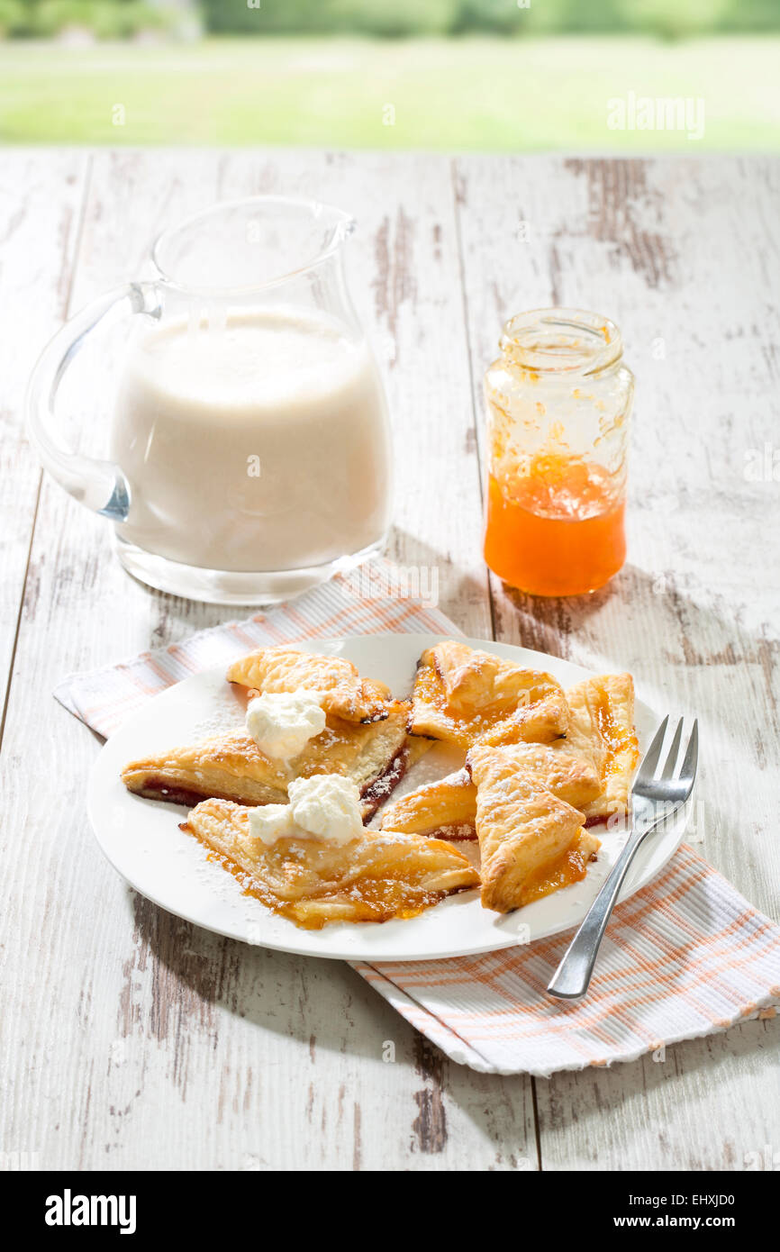 Puff pastry turnovers with apricot jam and whipped cream Stock Photo Alamy