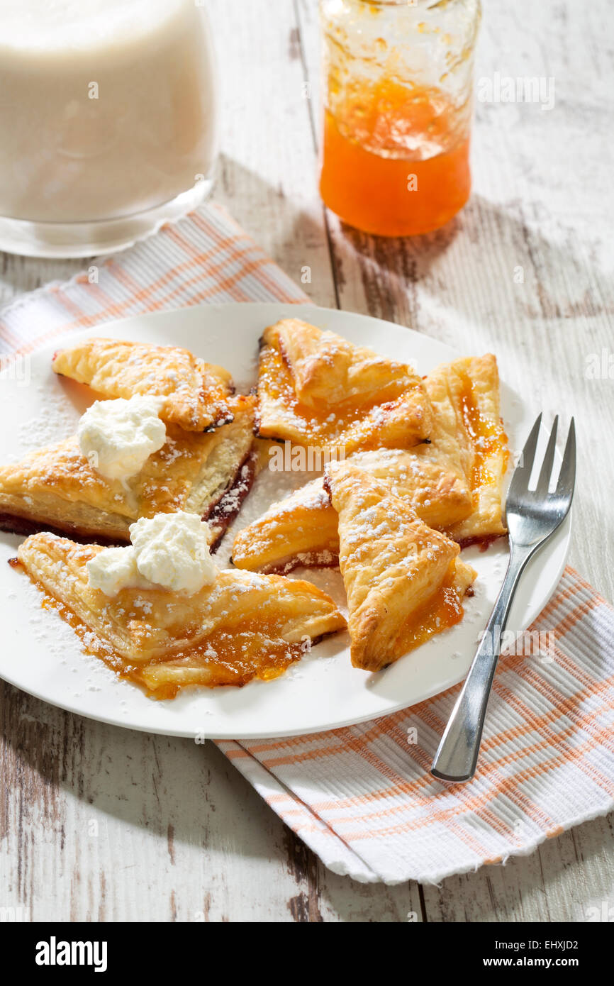 Puff pastry turnovers with apricot jam and whipped cream Stock Photo Alamy