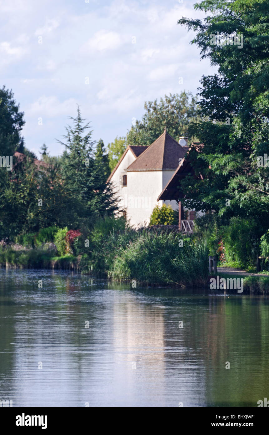 An overgrown garden surrounds an old house on the Canal du Centre near Chalon-sur-Saône, Burgundy, France. Stock Photo