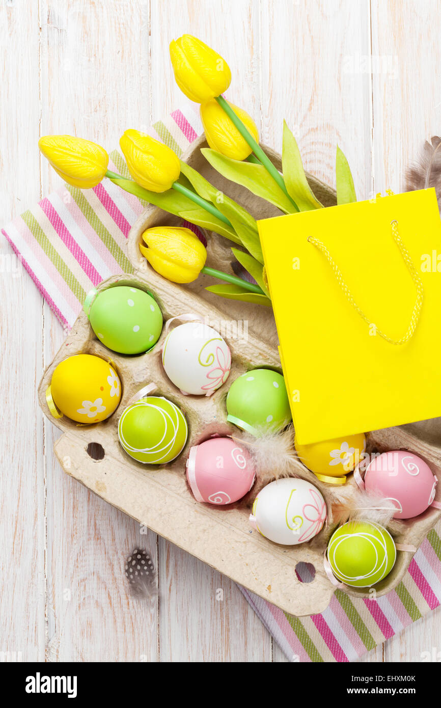 Easter with yellow tulips, colorful eggs and gift bag. Top view Stock ...