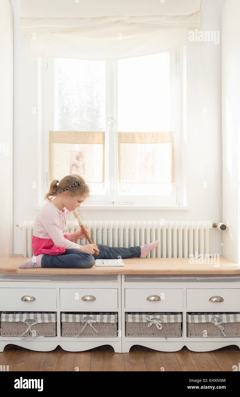 Little girl playing recorder at home Stock Photo