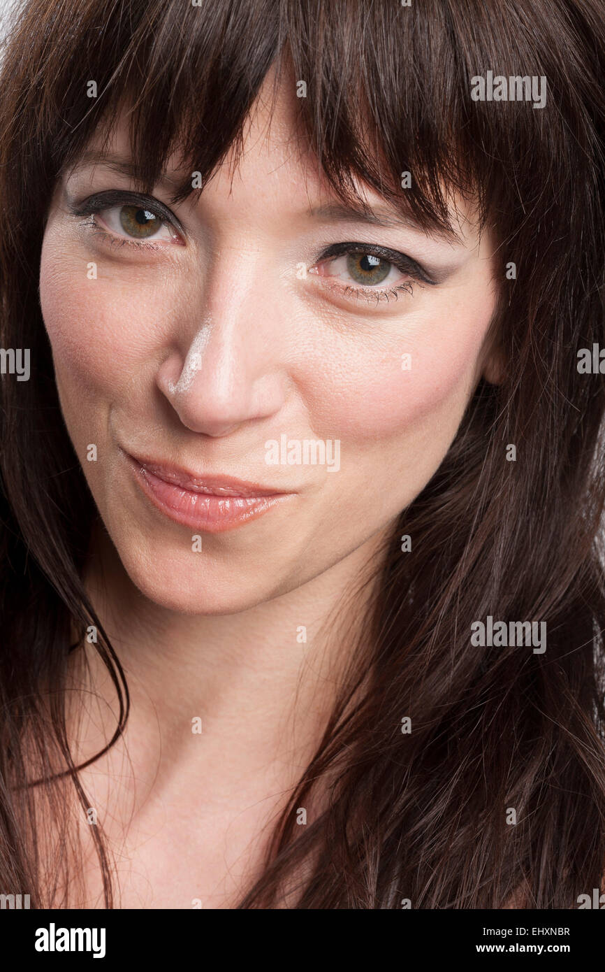 Portrait of smirking woman with dark long hair Stock Photo