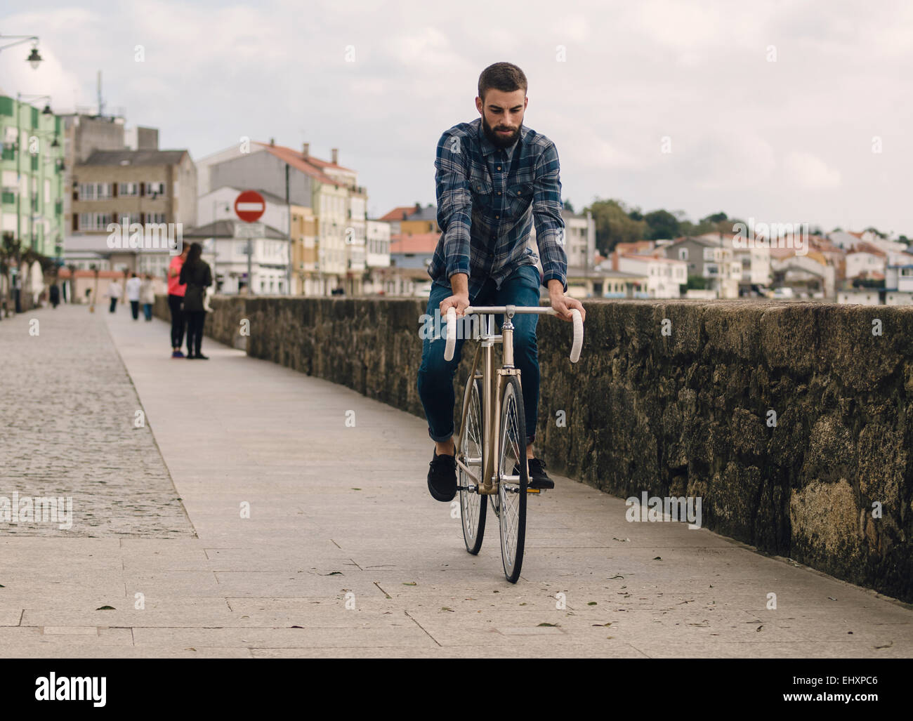 Spain, Galicia, Ares, hipster man riding with a fixie bike Stock Photo