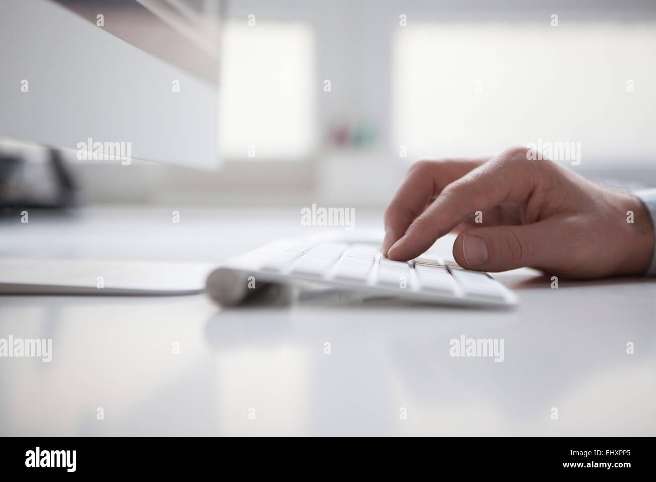 Man's hand typing on keyboard of computer Stock Photo