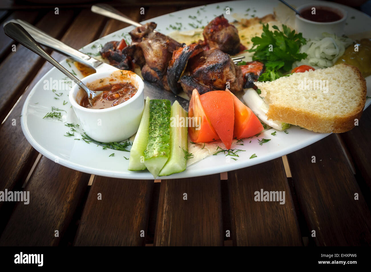 Nice and tasty dish of roasted meat with vegetables and souces Stock Photo