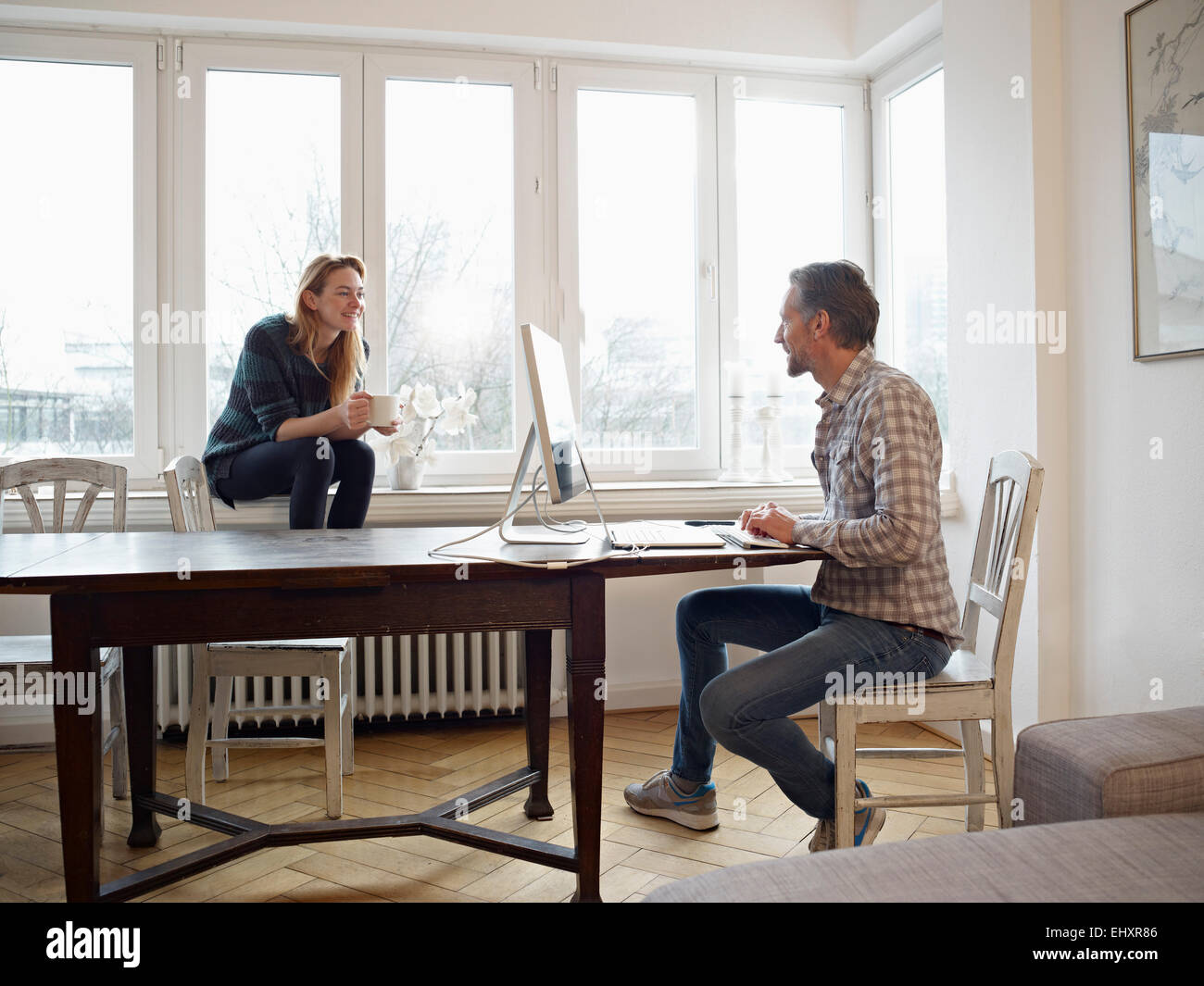 Germany, Cologne, Mature man and adult daughter at home, working at computer Stock Photo