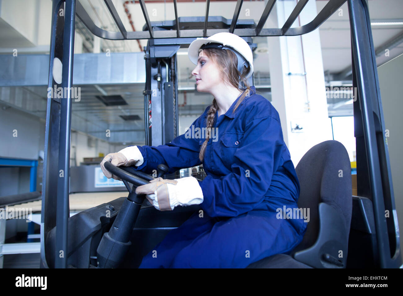 Worker in factory hall on forklift Stock Photo