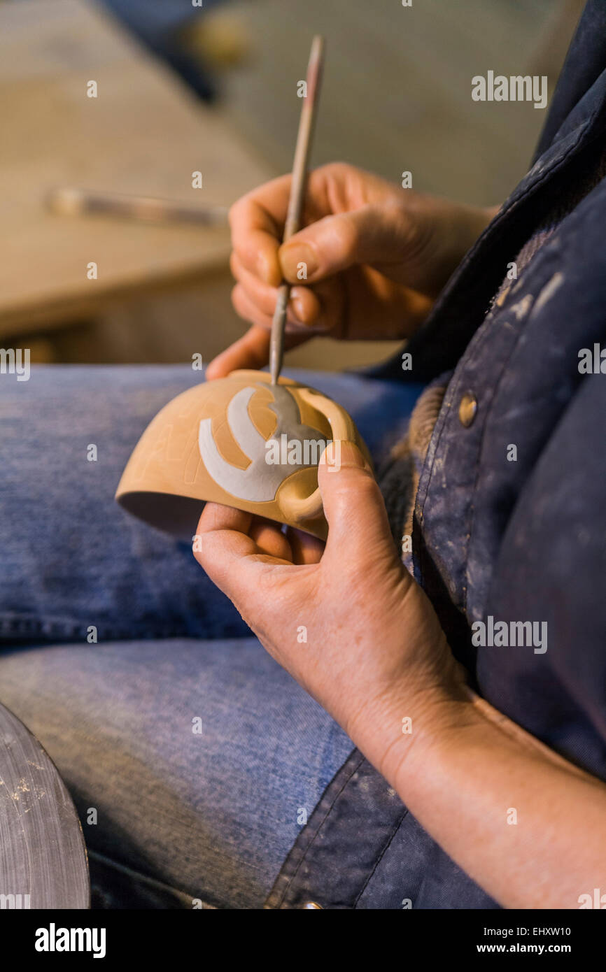Potter in workshop painting a bowl Stock Photo - Alamy