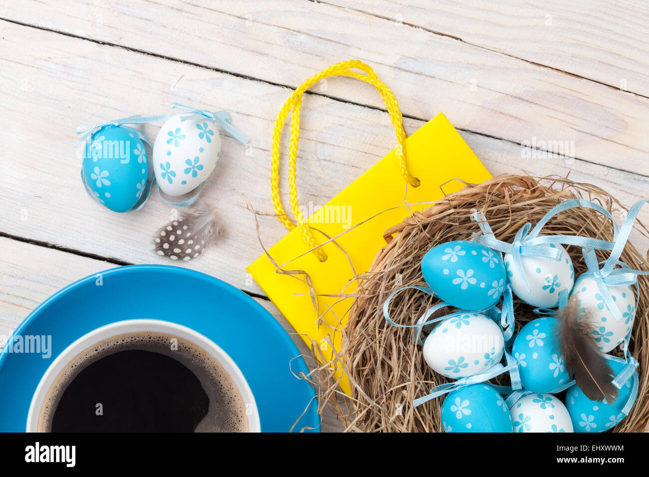 Easter background with blue and white eggs in nest, yellow tulips and ...