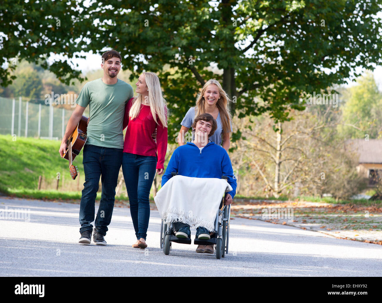 Young man in wheelchair with friends Stock Photo - Alamy