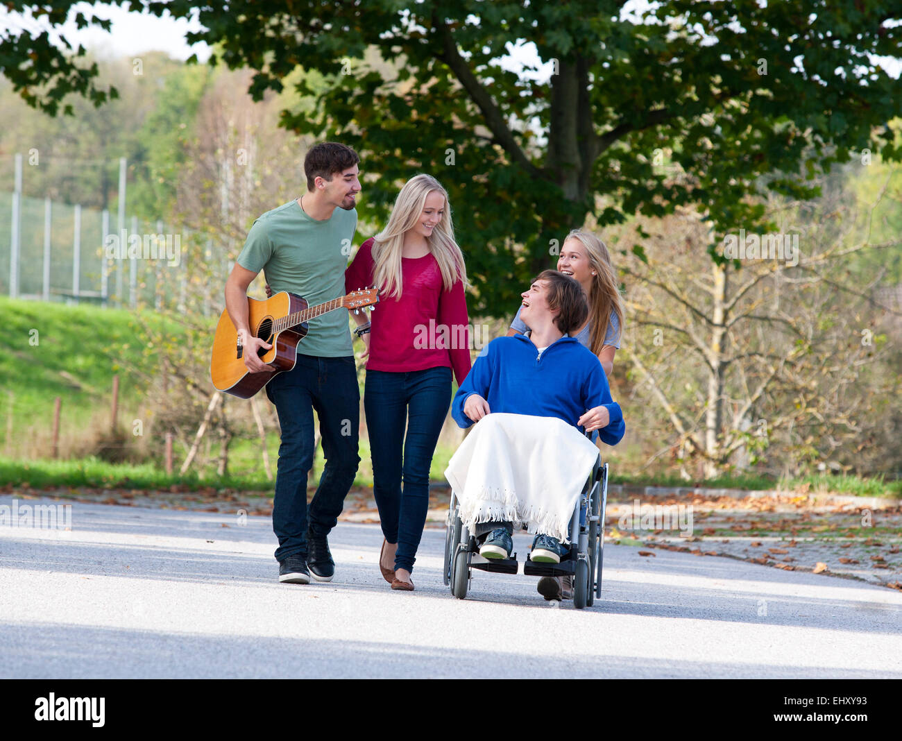Young man in wheelchair with friends Stock Photo - Alamy