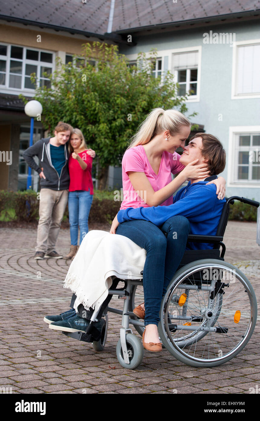 Young woman embracing her boyfriend sitting in wheelchair Stock Photo ...