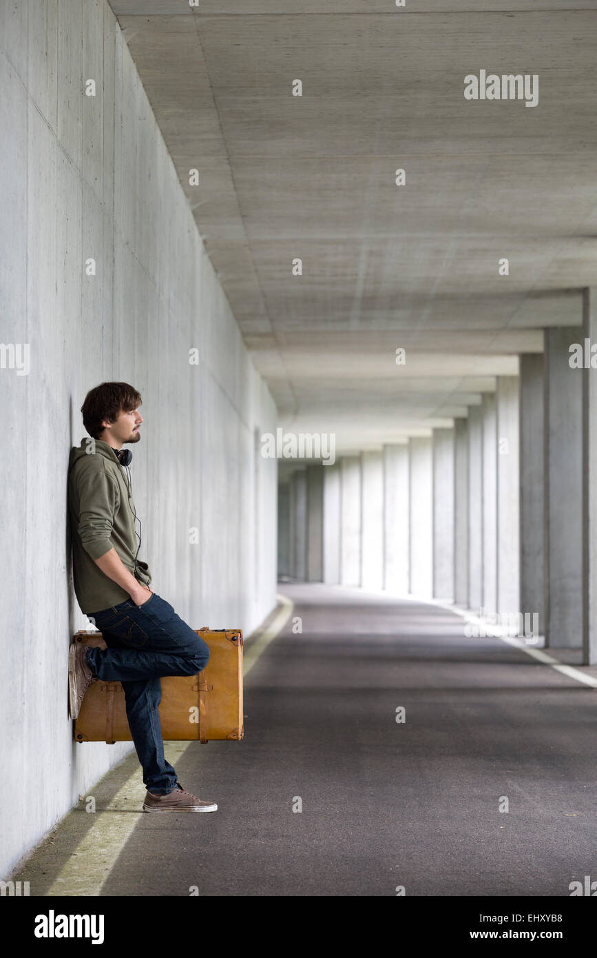 Man with leather suitcase waiting in a car park Stock Photo