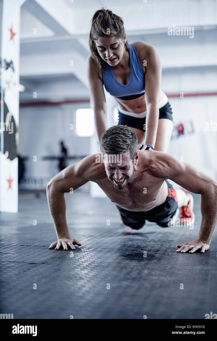 Man doing push ups with woman kneeling on his back Stock Photo Alamy