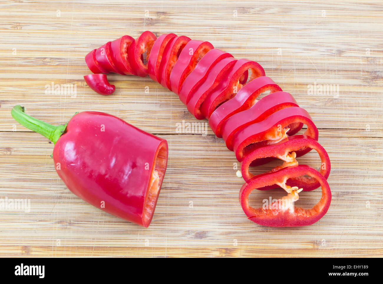 Sliced red ripe fresh pepper on cutting board Stock Photo